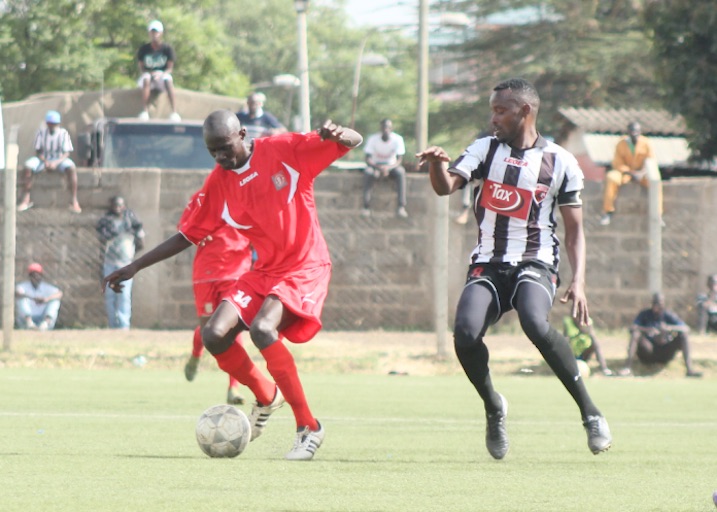 Ushuru's Edwin Mwaura accosts Administration Police midfielder Nicodemus Asumwa during their FKF National Super League match played at Camp Toyoyo. PHOTO/FKF