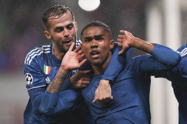 uventus' Douglas Costa, right, celebrates after scoring a goal during the Champions League soccer match between Lokomotiv Moscow and Juventus, in Moscow, Russia. PHOTO | AFP