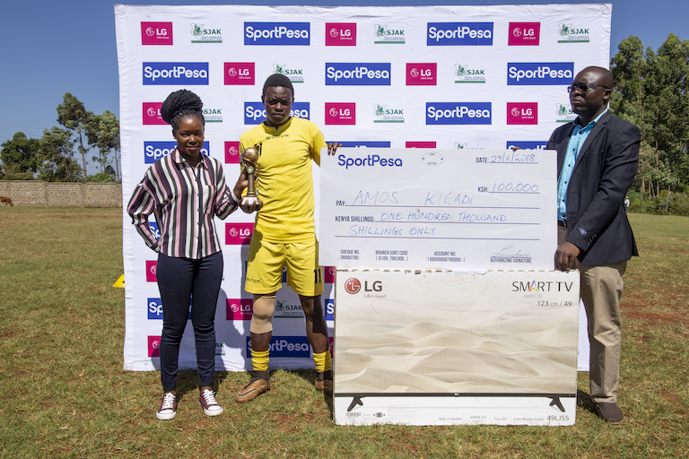 Vihiga United FC striker Amos Kigadi (centre) receives his SportPesa/SJAK Monthly Award for September/October flanked by SportPesa Digital Executive, Teresia Akoth (left) and Livingston Ihaji, the LG regional Brand Ambassador on Thursday, November 29, 2018. PHOTO/Duncan Sirma