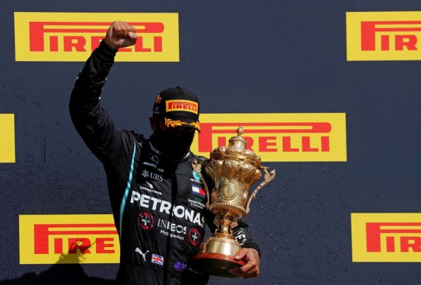 Winner Mercedes' British driver Lewis Hamilton celebrates with his trophy on the podium after the Formula One British Grand Prix at the Silverstone motor racing circuit in Silverstone, central England on August 2, 2020. Lewis Hamilton survived a dramatic finale to win the British Grand Prix on Sunday, just making it across the line on three tyres to beat a fast closing Max Verstappen on Red Bull. The defending world champion claimed his seventh British Grand Prix win as Ferarri's Charles Leclerc came third and Daniel Ricciardo of Renault fourth. PHOTO | AFP